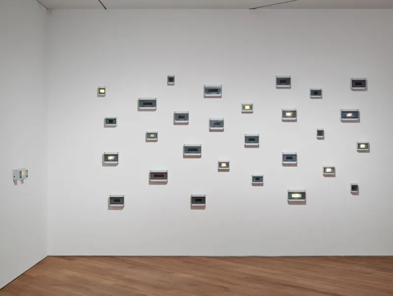 Joyce Joumaa
‘Periodic Sights’, 2025
Installation temporelle, impressions jet d'encre sur papier vélin, boîtiers électriques, minuteries électroniques, lumières LED
Dimensions variables 
Collection Mudam Luxembourg
Donation 2025 – Baloise
Vue d’exposition ‘Video Killed the Radio Star: The 1980s and Their Cultural Echoes’, 12.06-11.10.2026, Mudam Luxembourg 
Photo : Mareike Tocha © Mudam Luxembourg