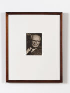 A black and white portrait of a man in a suit.