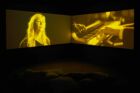 Gabrielle Goliath, ‘This song is for…’, 2019. Installation vidéo 4K couleur, son, 11 doubles projections synchronisées, texte vinyle. 201 min 36 sec (11 chansons). Collection Mudam Luxembourg. Donation 2024 – A&O Shearman. Vue de l’exposition ‘I’ve grown roses in this garden of mine’, 03.10-31.10.2019, Goodman Gallery, Londres © Goodman Gallery, Londres