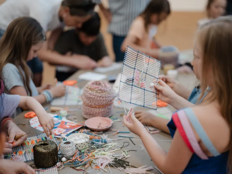 Enfants participant à un atelier créatif de tissage au Mudam.