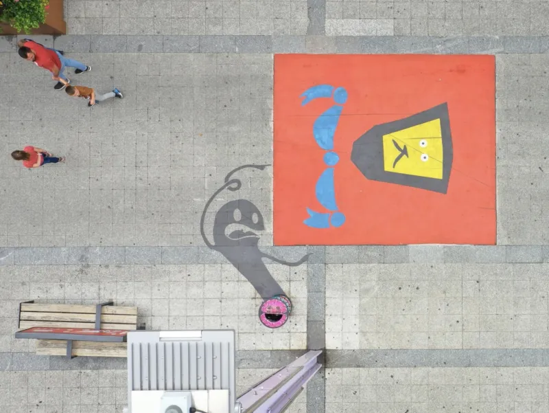 Graffiti painted on an outdoor floor, photographed from above.