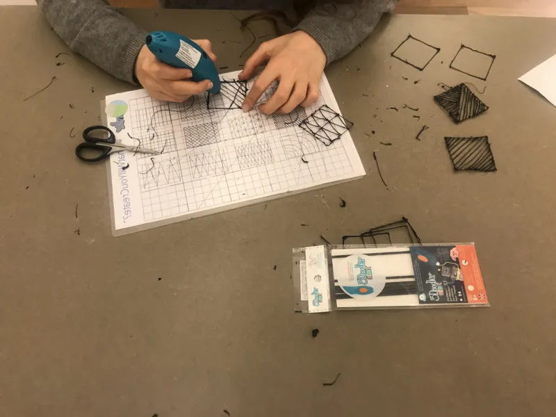 A child using a 3D pen.