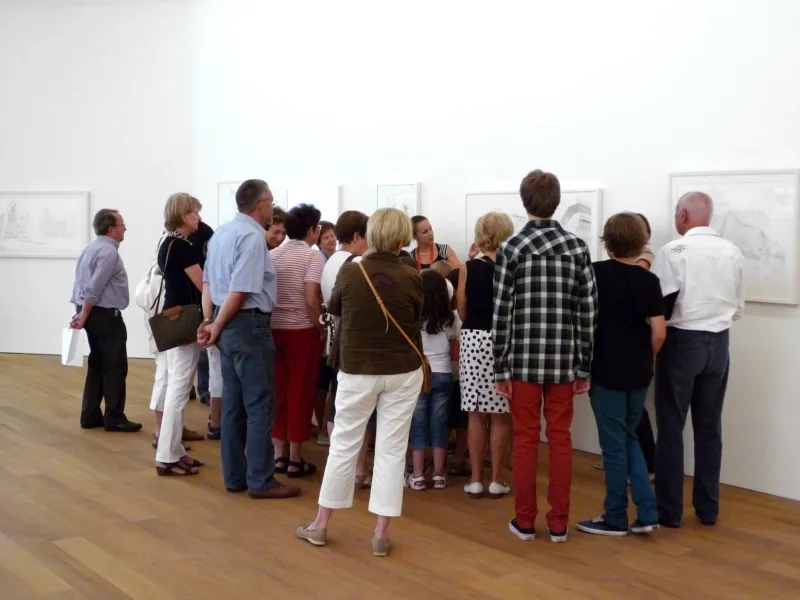 A group of persons taking part in a museum tour.