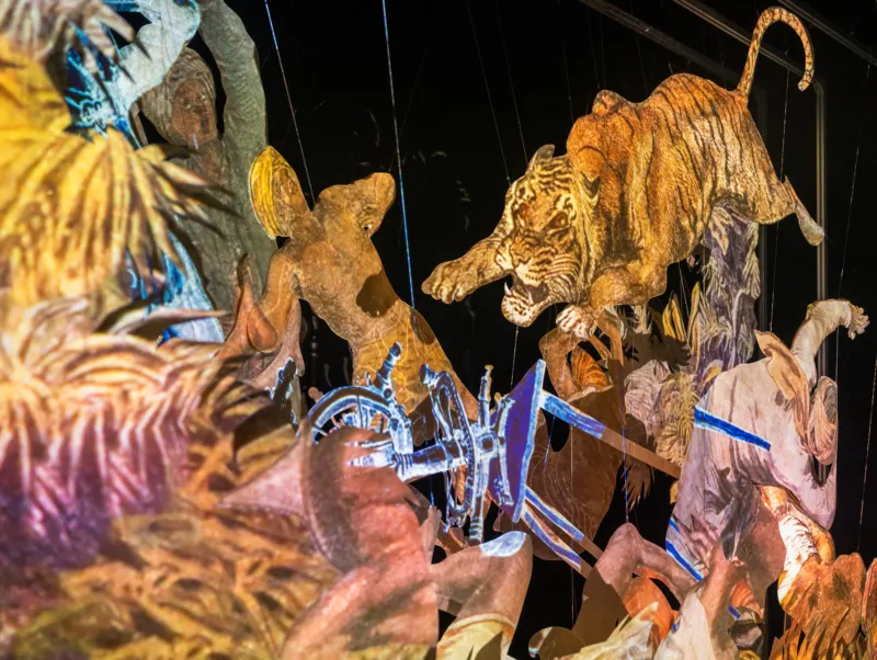 Papercut of a scene representing a tiger attacking people.