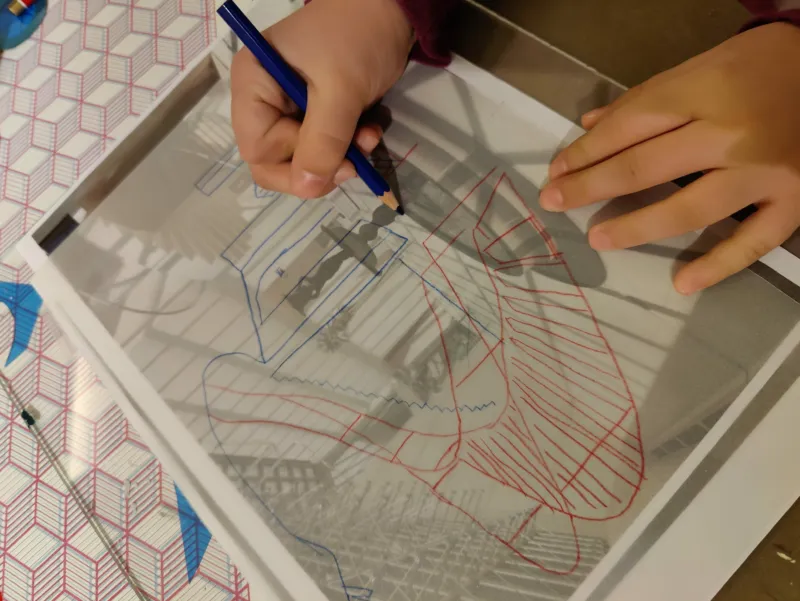 A child copying a photo by drawing over it.