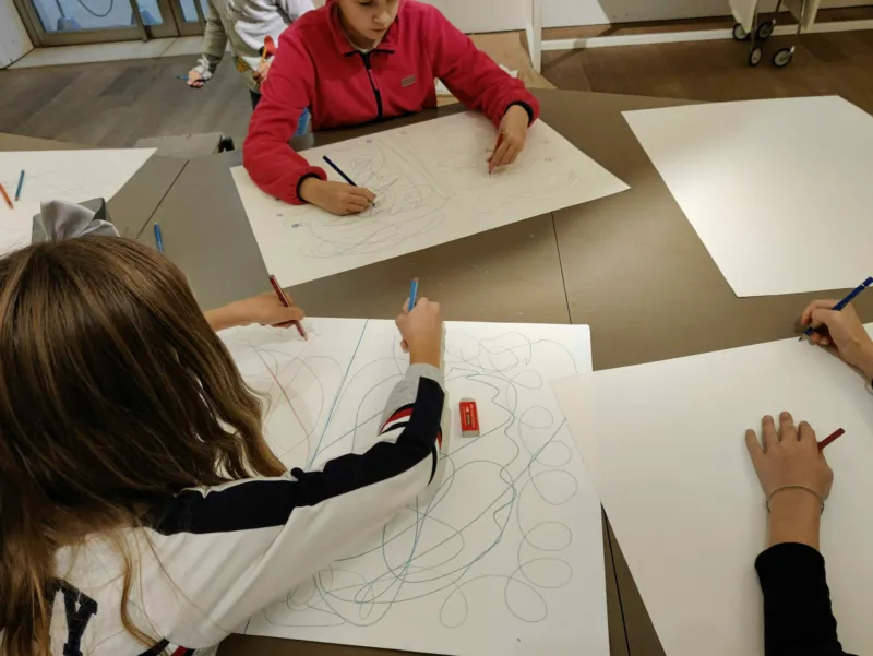 Children drawing right and left handed simultaneously during a workshop at Mudam.