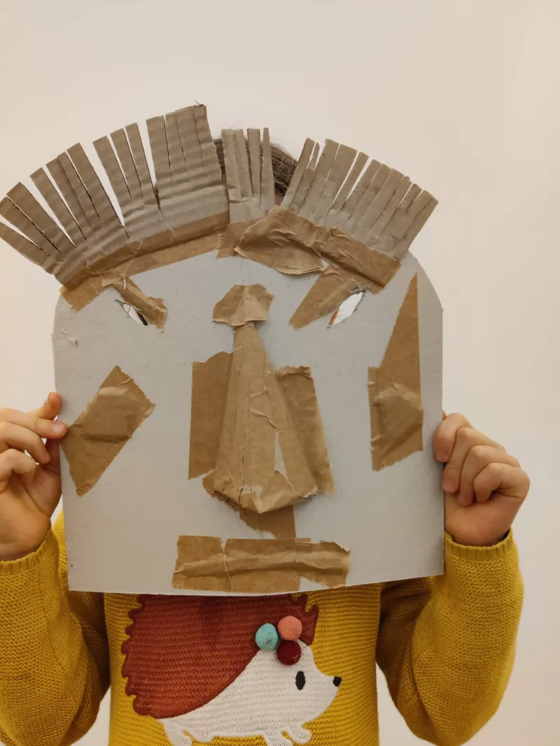 A child wearing a self-made cardboard mask.