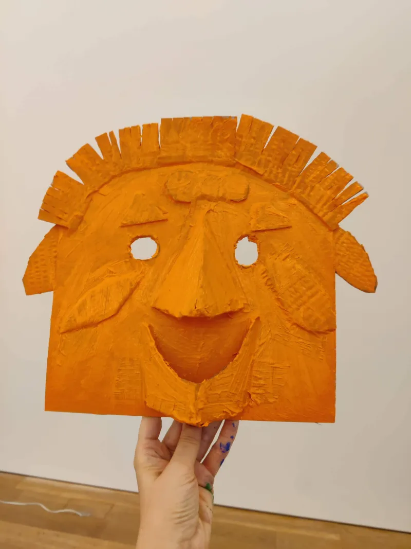 An orange mask made in a children's workshop at Mudam.