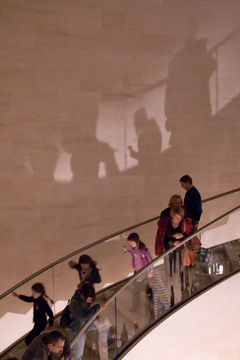 A family visiting Mudam, descending the main stairs in the Grand Hall.