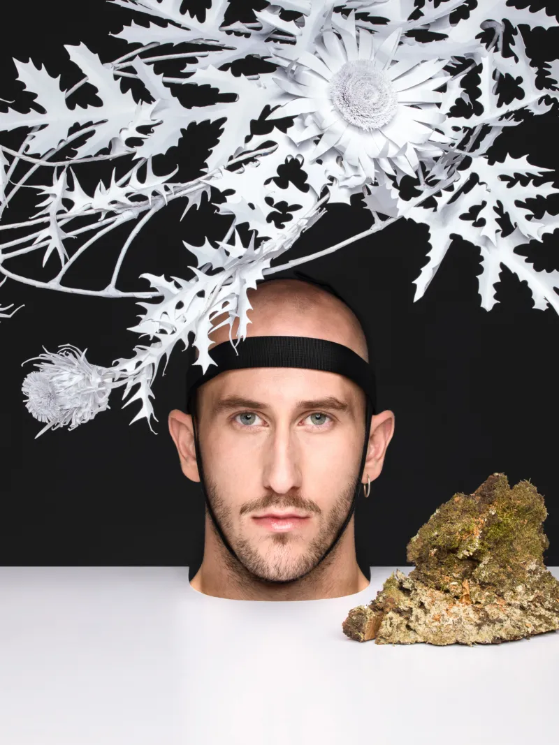 A head with a beautiful white paper flower crown.