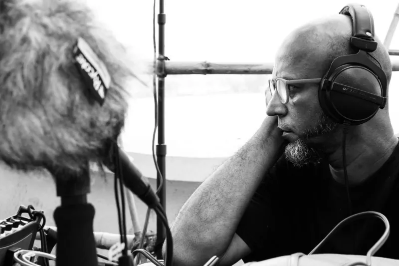 Black and white photo of a person with headphones and a microphone.