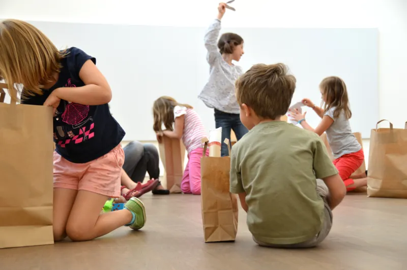 Children unwrapping present bags at Mudam.