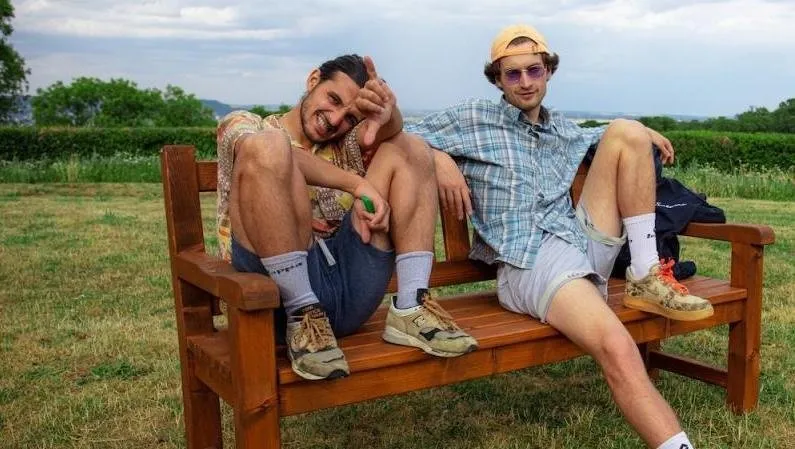 Deux hommes sur un banc en pleine campagne.