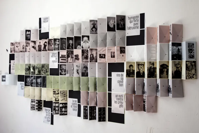 Leporellos of various photographies hanging on the wall.