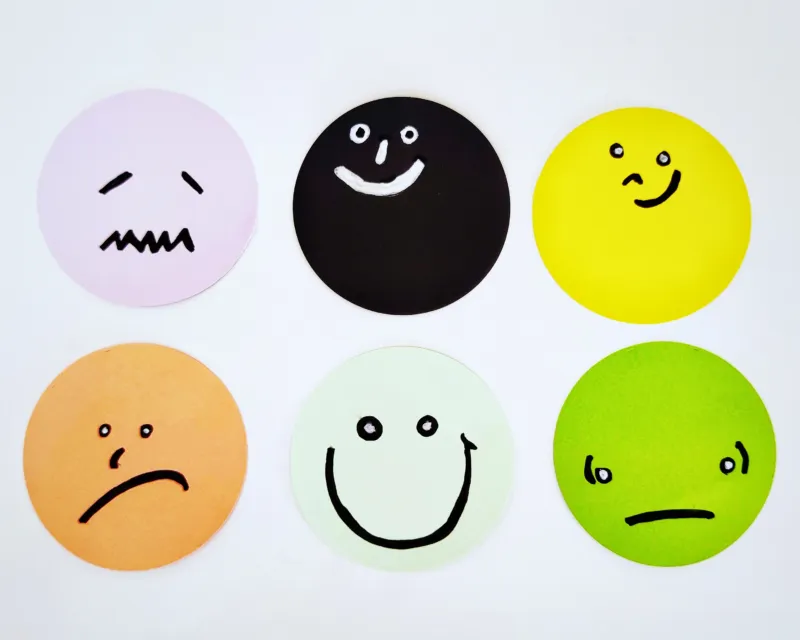 A variety of faces drawn on different coloured circles.
