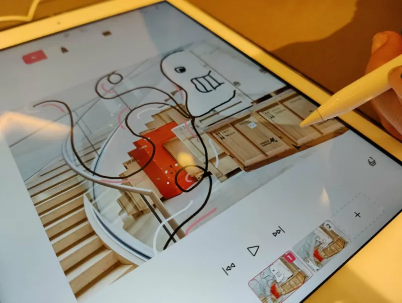 Une tablette avec un cartoon dessiné sur une photo d'une exposition du Mudam.