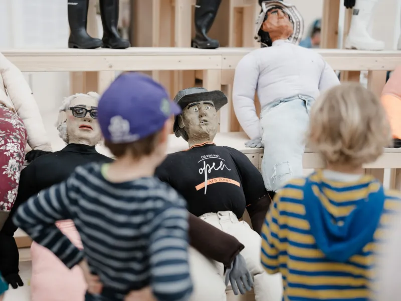 Oscar Murillo, ‘collective conscience’, 2015-ongoing, detail. 30 papier mache and fabric effigies, wooden bleachers. Courtesy of the artist. View of the exhibition ‘A Model’, Mudam Luxembourg © Photo: Marion Dessard | Mudam Luxembourg