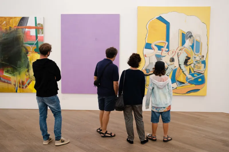 A family with kid looking at a painting in a Mudam gallery.